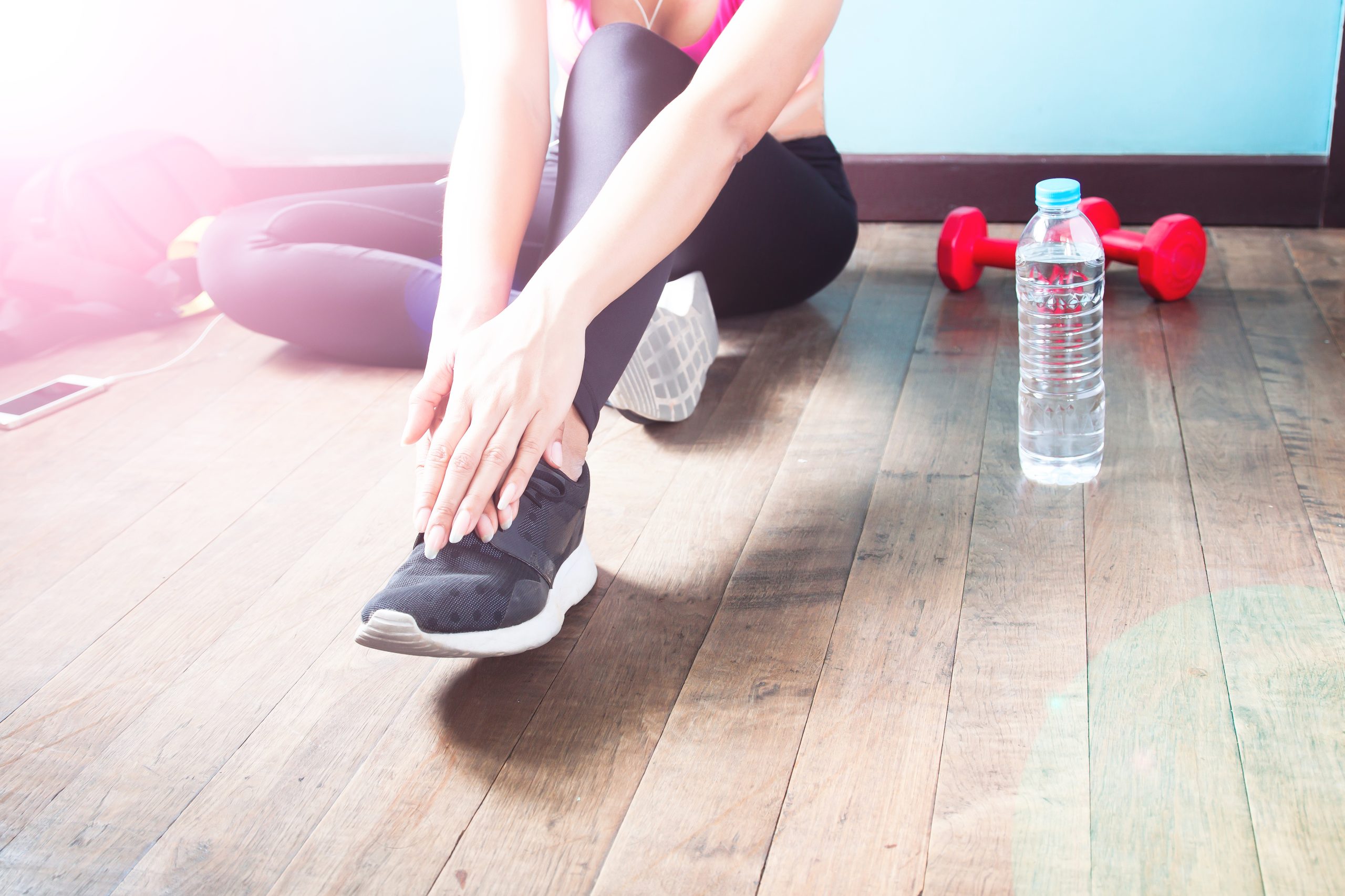 Fitness female in black pants and sneaker stretching after workout with copy space